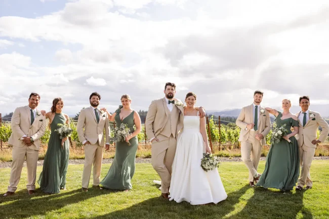 The wedding party posing in front of the vineyard at Ghost Hill Cellars
