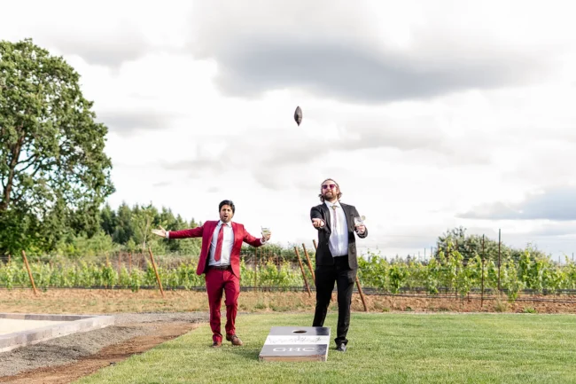Guests playing corn hole at Anne and Joey's winery wedding at Ghost Hill Cellars in Carlton, Willamette Valley, Oregon