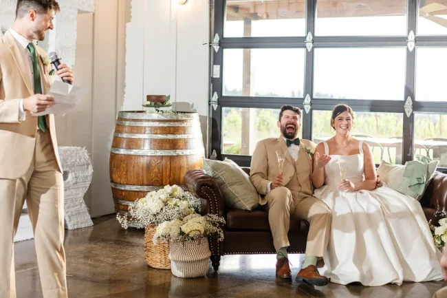 The bride and groom sitting on a comfortable couch during the Best Man speech