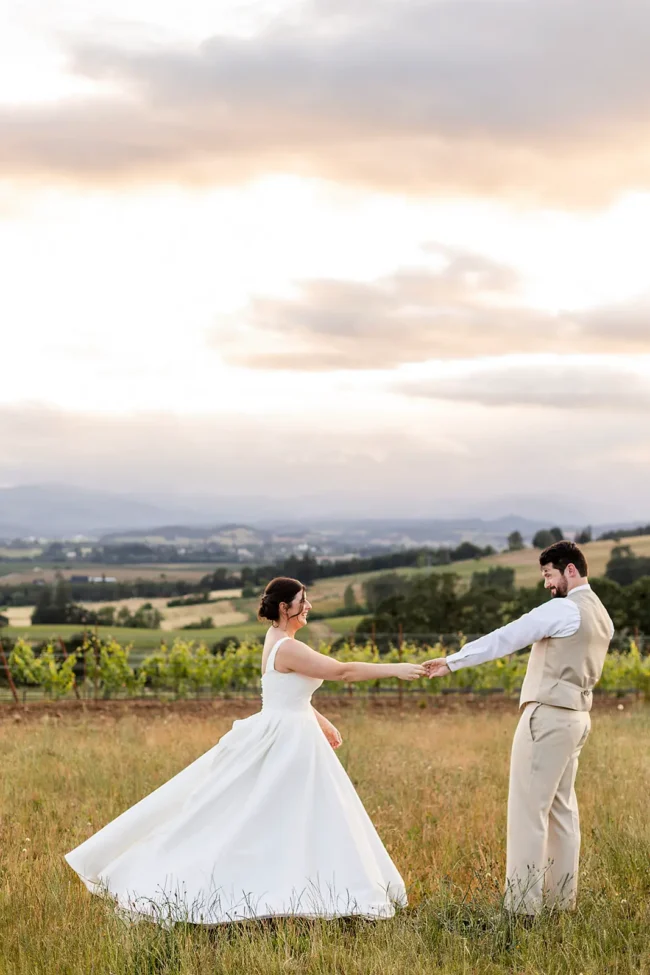Anne and Joey dancing across the field at Ghost Hill Cellars on their wedding day